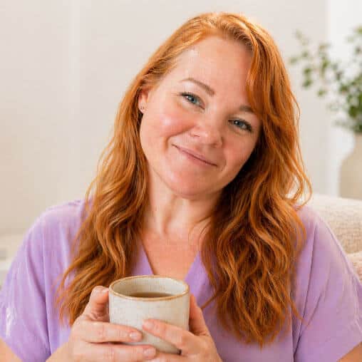 Emma Combes Smiling red-haired woman holding a ceramic mug